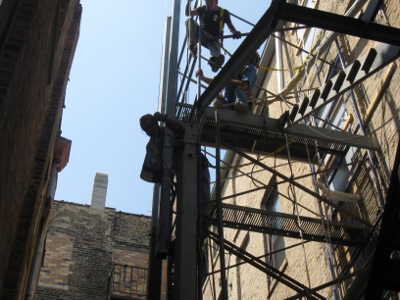 A Worker on a Steel Fire Escape Construction Project for a Multi-Story Apartment Building