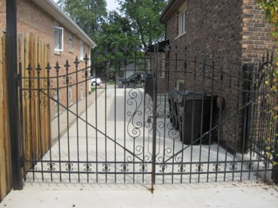 A Decorative and Functional Iron Driveway Gate Limits Access to the Backyard and Garage