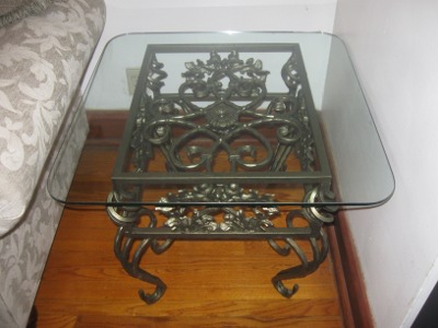 A Table with Iron Scroll Work Base and Glass Top