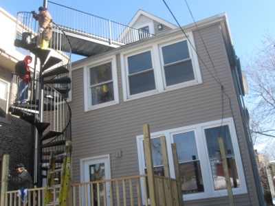 A spiral staircase and walkway construction project to a second story deck